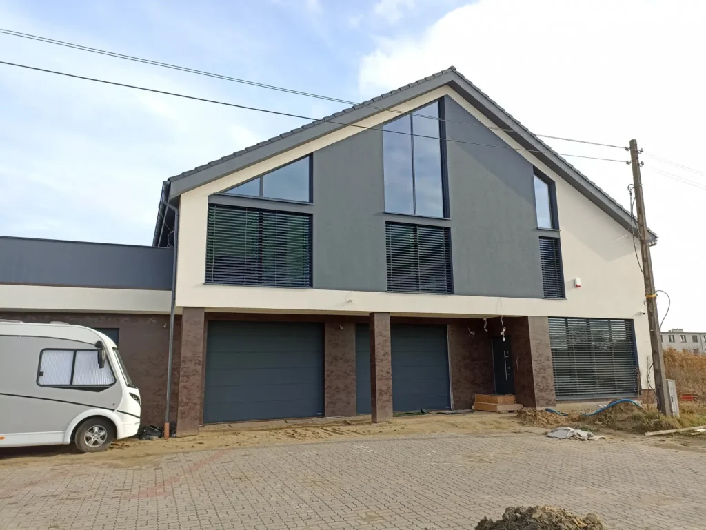 Budowa domów Poznań - dom z użytkowym poddaszem, dachem dwuspadowym i garażem